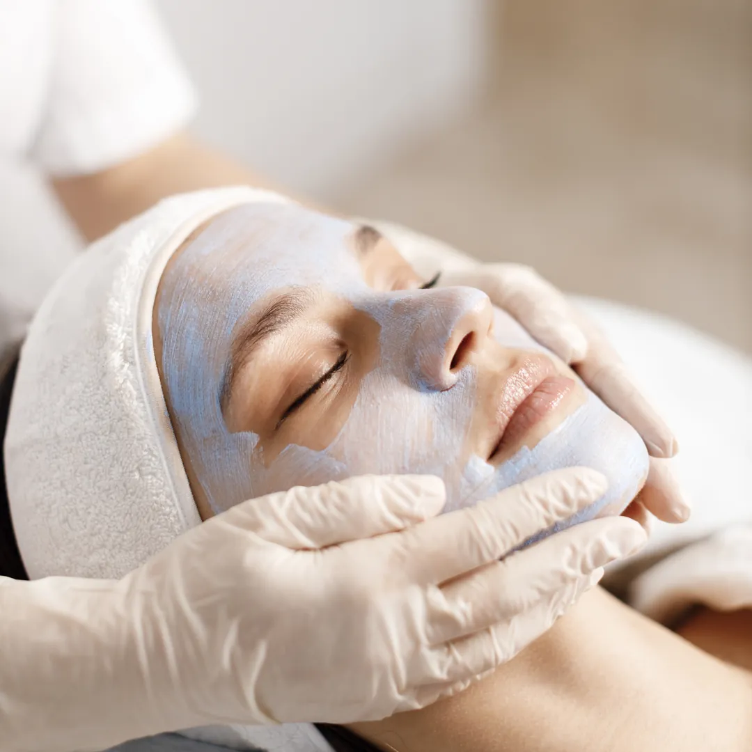 Cliente de olhos fechados recebendo máscara facial