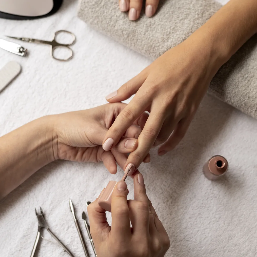 Manicure sendo feita com alicate e cutelaria sobre a toalha